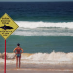 woman-in-beach-with-shark-sign